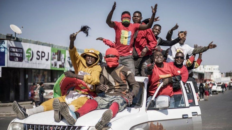 Supporters of Zambian President elect for the opposition party United Party for National Development (UPND) Hakainde Hichilema gestures as they ride on a pick up truck in the streets of Lusaka on August 16, 2021.