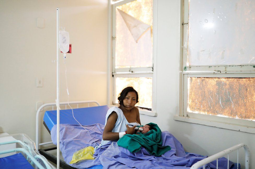 Maria Teresa Lopez, 20, a Warao Indian from Delta Amacuro state, uses a syringe to feed her one-day-old baby Fabiola, at a maternity hospital in Boa Vista.