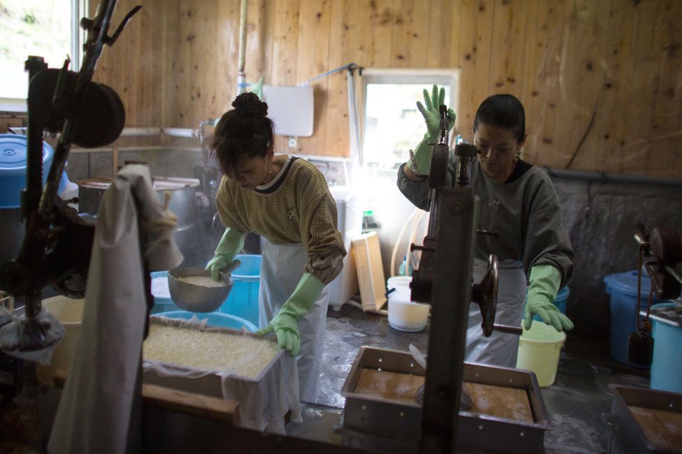 Women work in a small tofu factory, one of the few remaining businesses in her village, on April 22, 2016 in Ochiai, Miyoshi, Japan