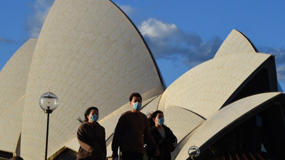 Люди в масках у Сиднейского оперного театра