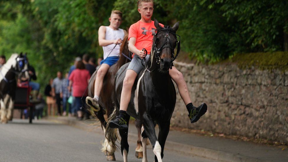 Two young men riding horses