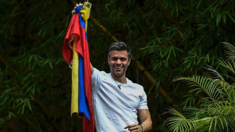 Venezuelan opposition leader Leopoldo Lopez displays the Venezuelan national flag as he greets supporters gathering outside his house in Caracas (08 July 2017)