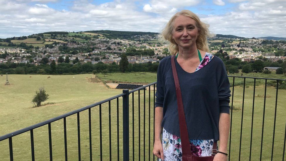 Cheryl standing on a balcony with Gloucestershire countryside in the background