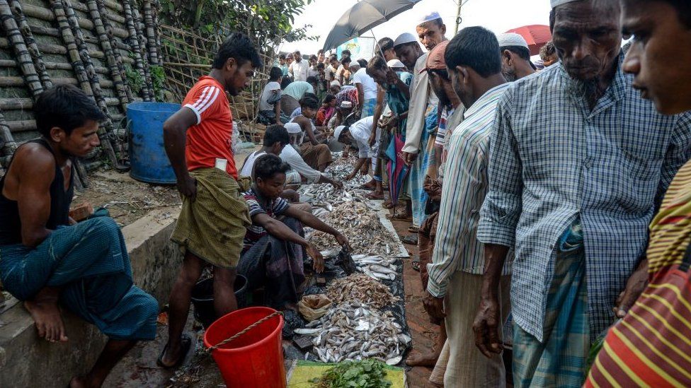 Rohingya refugees buy fish at a market place in Kutupalong refugee camp in Ukhia on October 8,