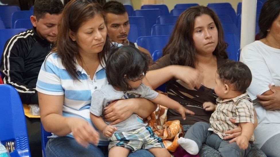 Mothers and children wait to be assisted by volunteers in a humanitarian centre in the border town of McAllen, Texas on 14 June 2018.