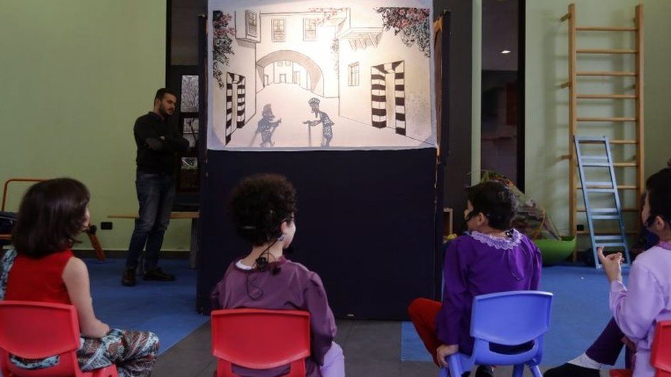 Syrian children watch a performance by the country's last shadow puppeteer Shadi al-Hallaq in Damascus on 3 December 2018.