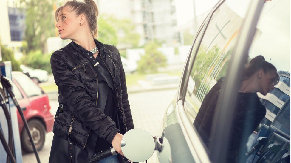 Woman filling up car with petrol