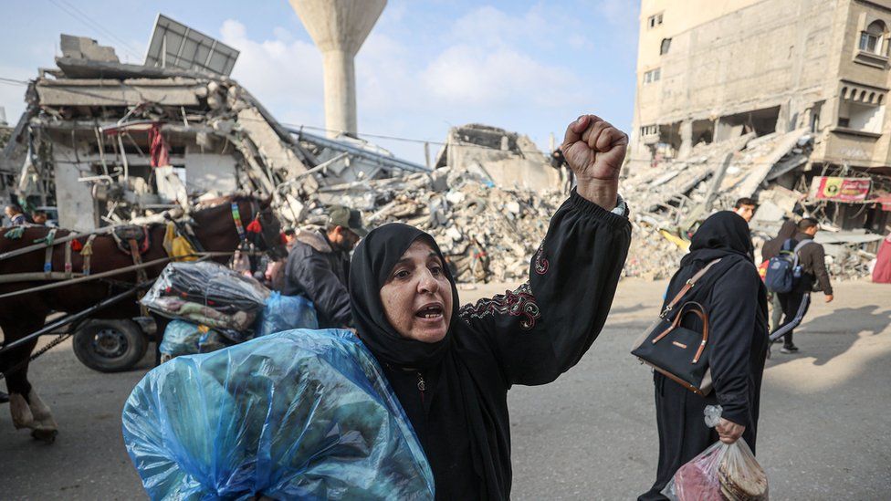 Palestinian woman leaving Khan Younis with her belongings