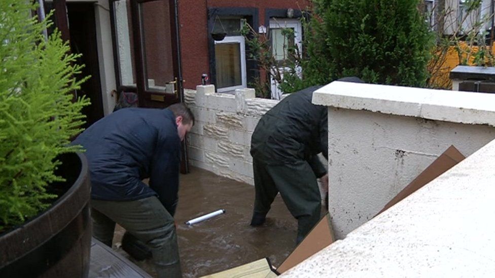 People clearing flood water