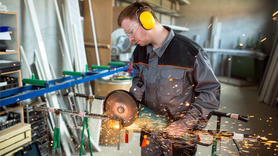 Worker cutting metal with grinder