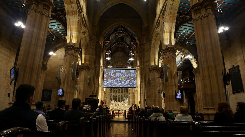 Members of the public view the televised funeral of Queen Elizabeth II at St. Andrew's Cathedral in Sydney, Australia