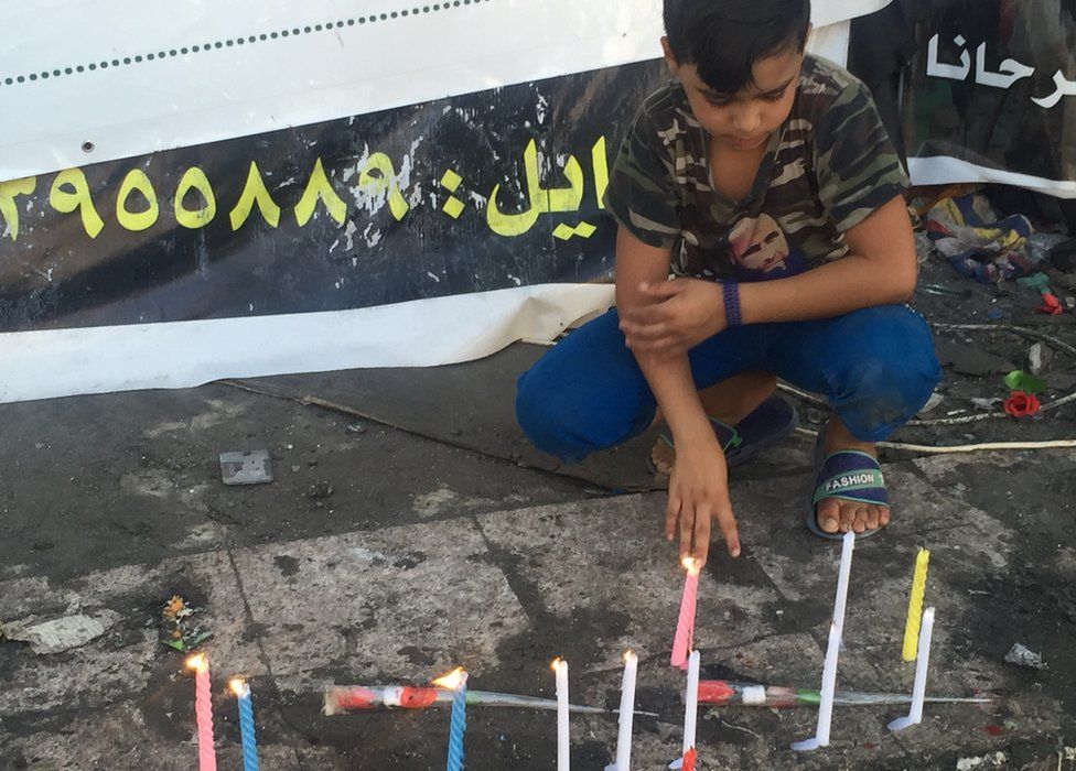 An Iraqi boy looks at candles at a shrine in Baghdad