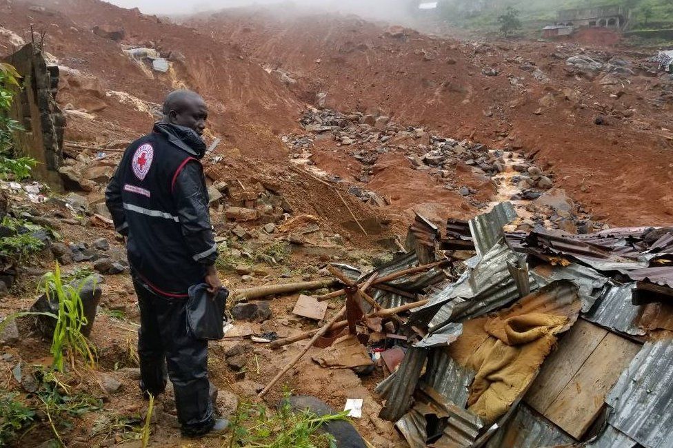A Red Cross worker looks out across the wreckage of the mudslide