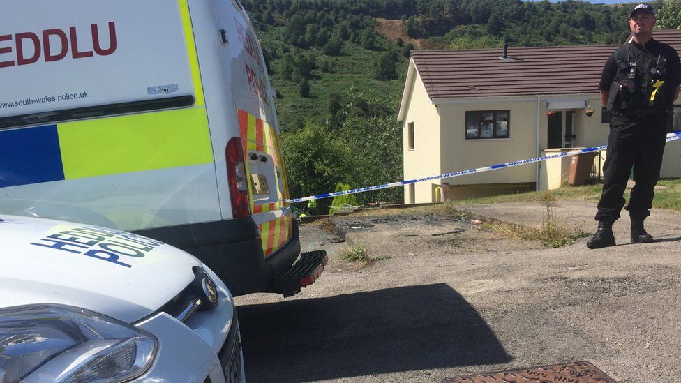 Police officers put a cordon around the house