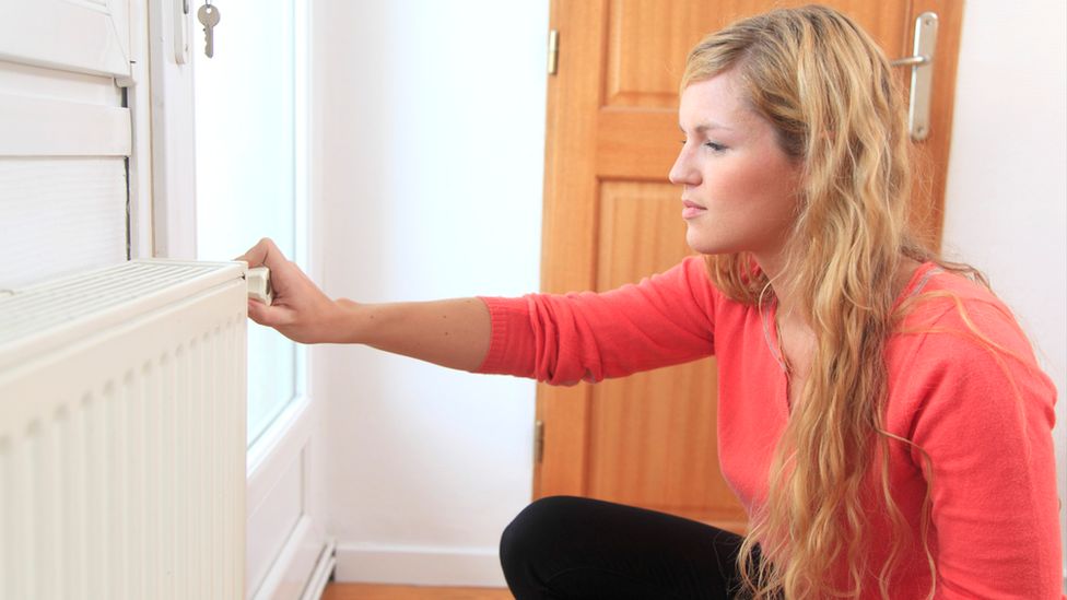 Woman adjusts radiator