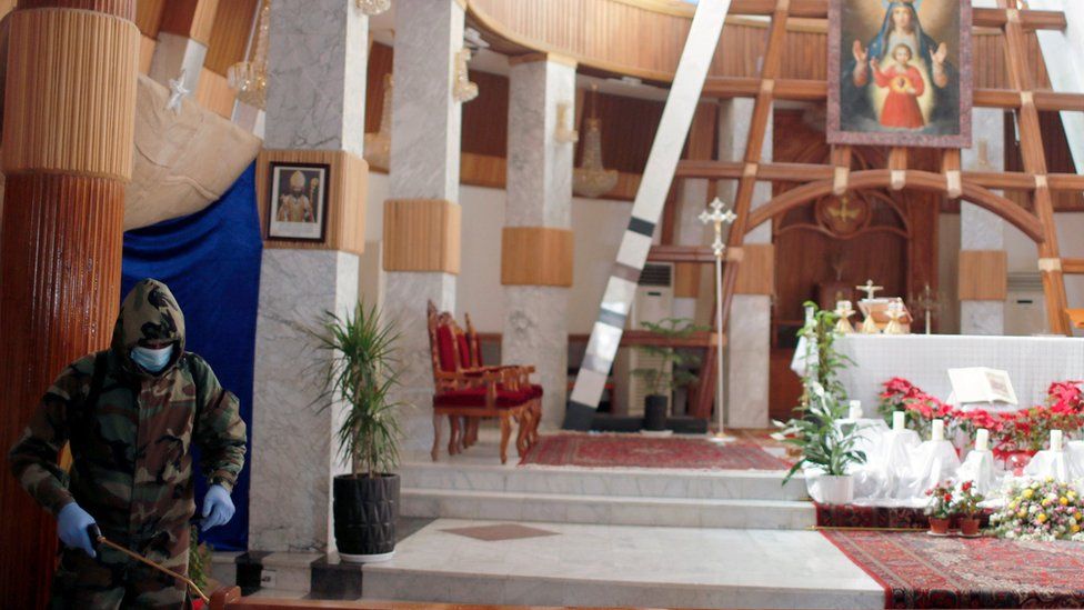 Сотрудник гражданской обороны дезинфицирует церковь Богоматери Спасения в Багдаде (30 декабря 2021 г.)