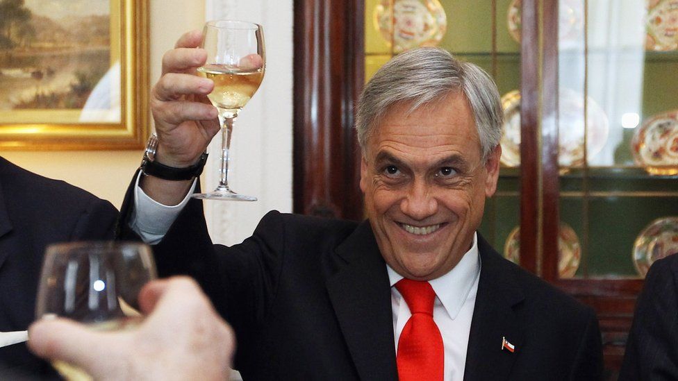 Mr Pinera raises a glass of wine during a trip to London in late 2010