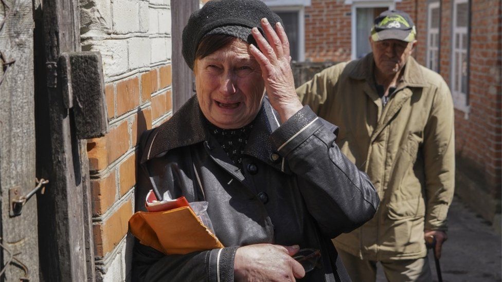 An elderly local woman reacts in grief upon the exhumation of the body of a man killed in the Mala Rohan village near Kharkiv, Ukraine, 23 May 2022