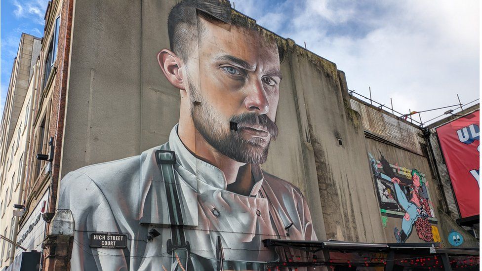 A painting of a man in a chef's uniform on a wall at High Street Court in Belfast