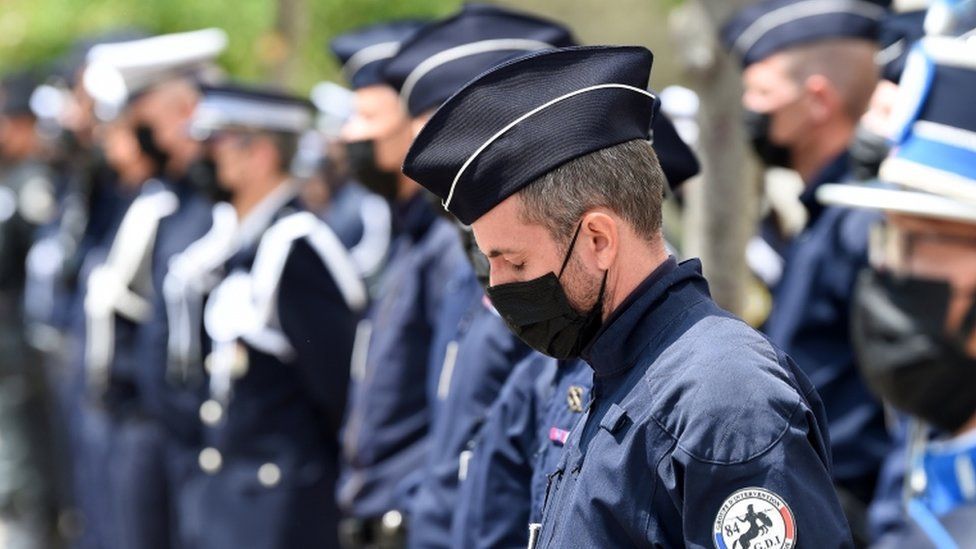 French police officers stand at the ready as they attend a ceremony to pay tribute to police officer Eric Masson, who was killed on May 5 during an anti-drug operation
