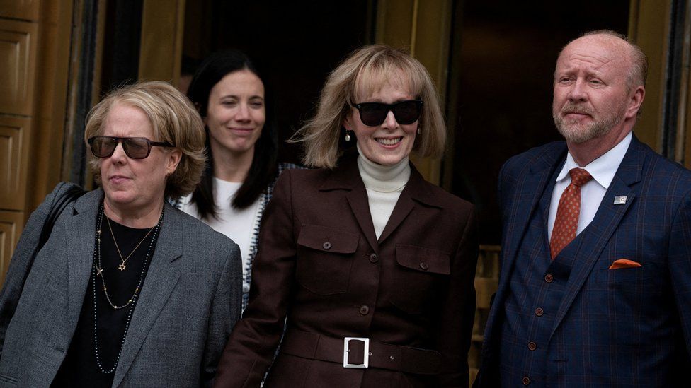 Писательница Э. Джин Кэрролл (в центре) выходит из Федерального суда Манхэттена после того, как в мае присяжные признали Дональда Трампа виновным в сексуальных домогательствах и клевете