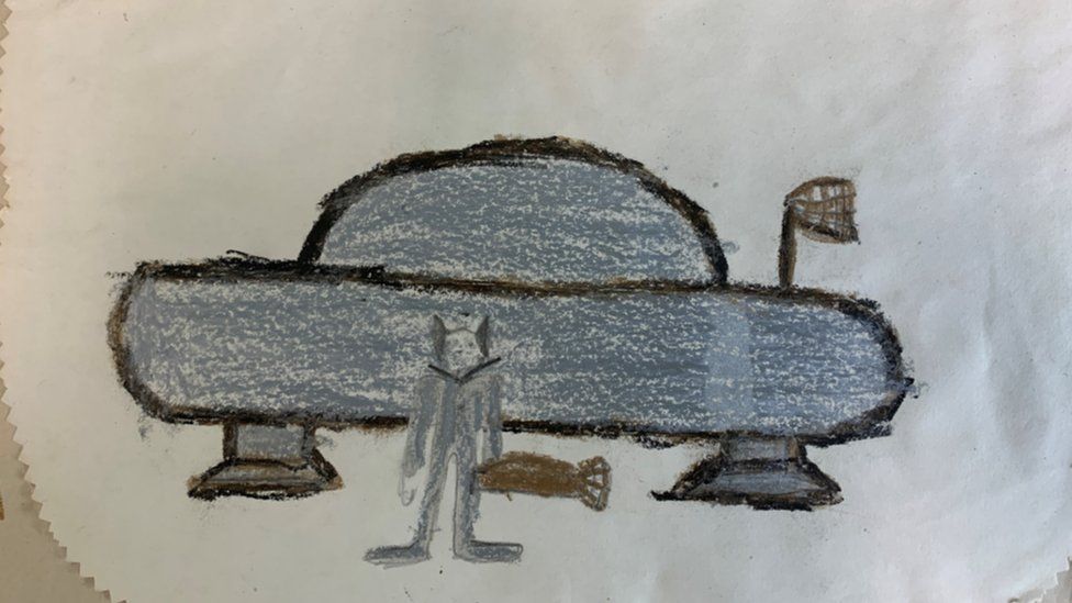 A child's drawing of a UFO and an alien
