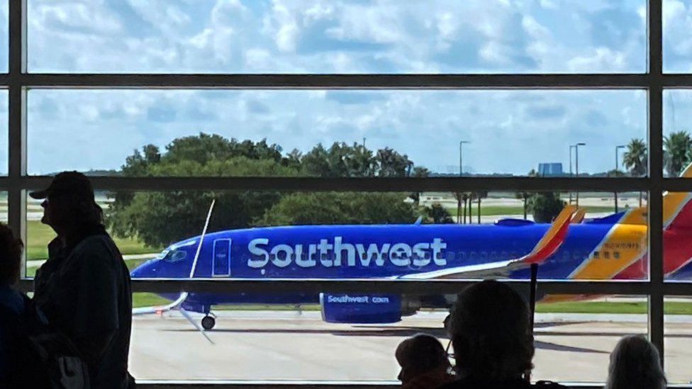 A Southwest Airlines plane taxis on the tarmac in preparation for takeoff at Orlando International Airport.