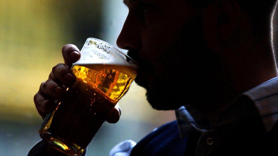 A man drinking a pint of lager