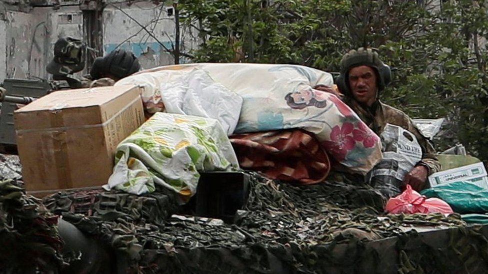 Close up shows looted possessions on a Russian tank