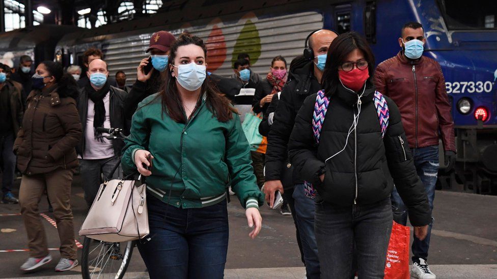 Commuters wearing face masks walk through Saint-Lazare station in Paris, 11 May 2020