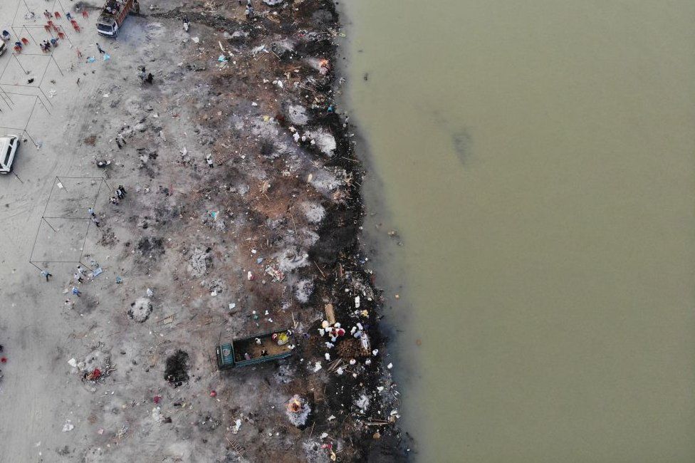 На этом аэрофотоснимке, сделанном 5 мая 2021 года, погребальные костры жертв коронавируса Covid-19 видны на месте кремации на берегу реки Ганг в Гархмуктешваре