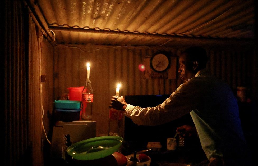A man uses candles to light his home.