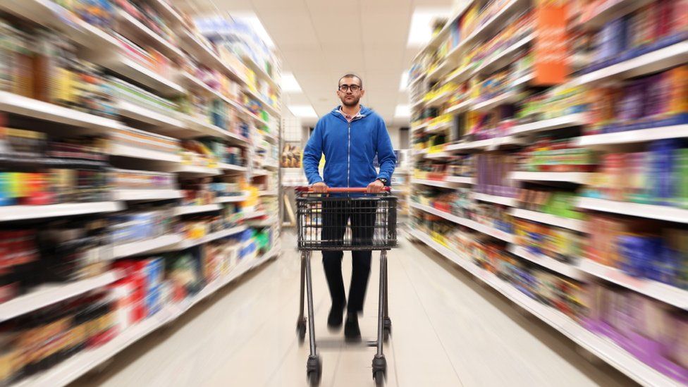 Мужчина с тележкой в ​​супермаркете