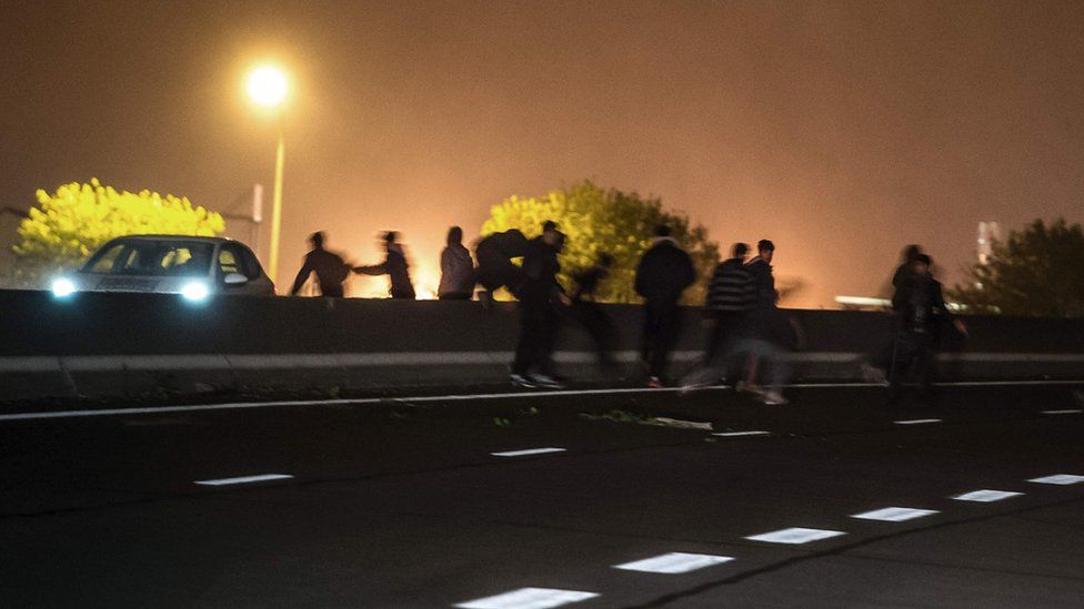 File pic of migrants crossing main road near Calais