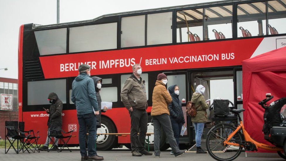 Люди стоят перед прививочным автобусом, чтобы сделать прививку от COVID-19, 17 ноября 2021 года в Берлине