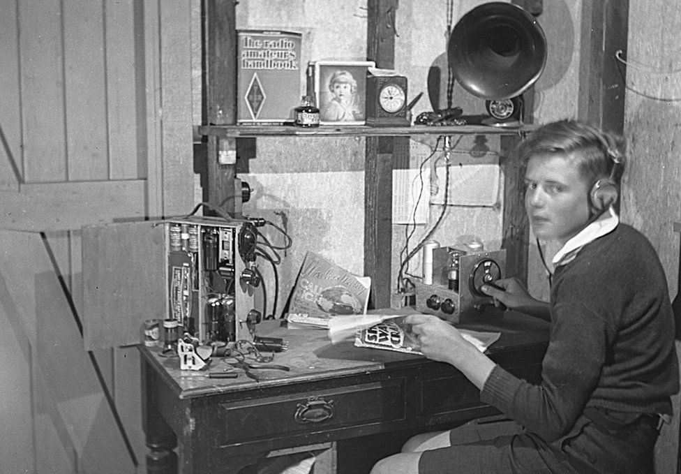 David pictured as a boy, wearing headphones and using his radio equipment