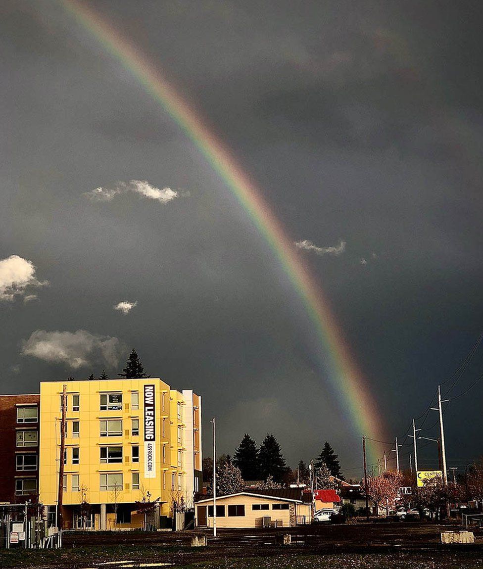 Rainbow in an overcast sky above buildings