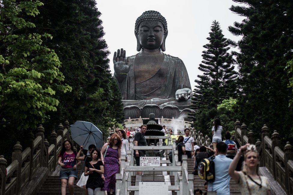 Tourists are seen on the stairs leading to the Big Buddha near the Po Lin Monastery on the outlying island of Lantau in Hong Kong on 9 June 2015.