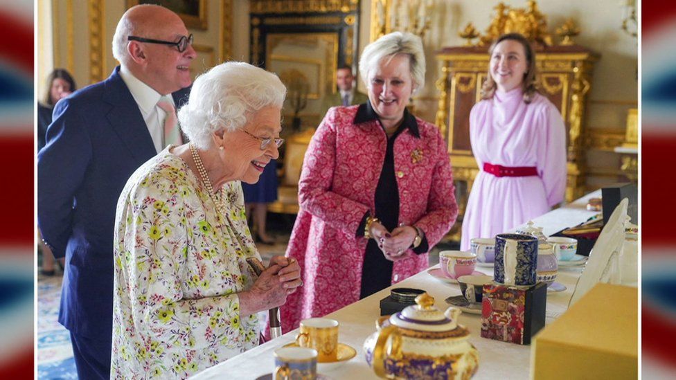 The Queen looks at chinaware