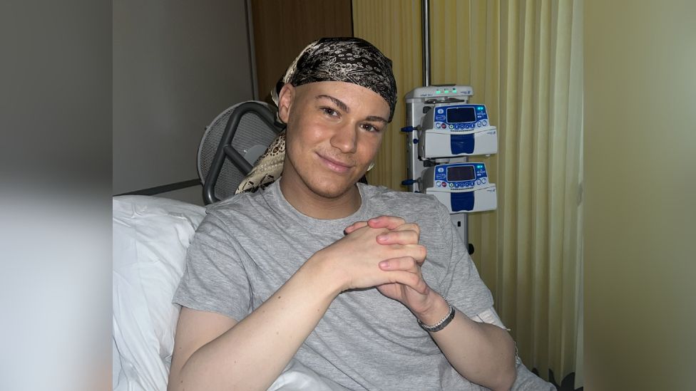 Man with head scarf on in hospital ward