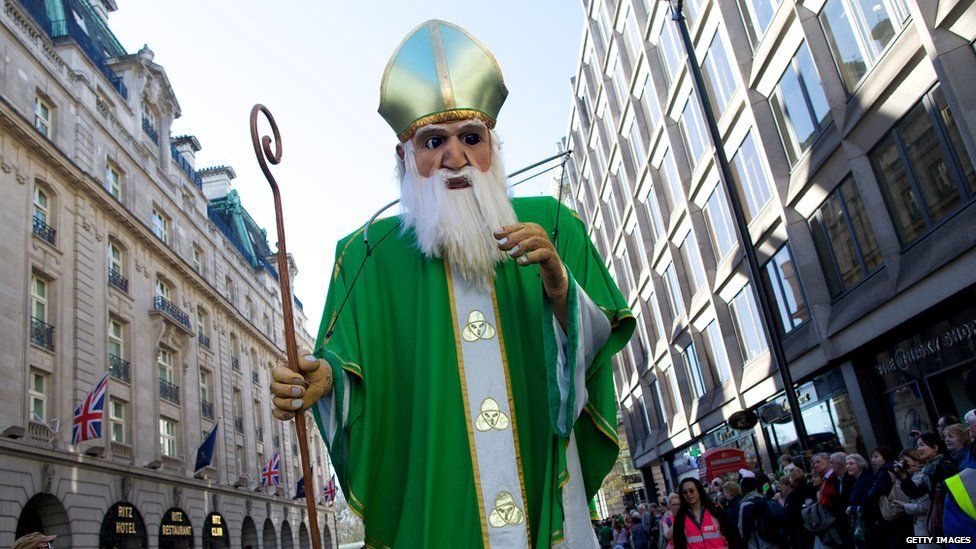 A giant float of St. Patrick is taken through the streets of London during a parade.