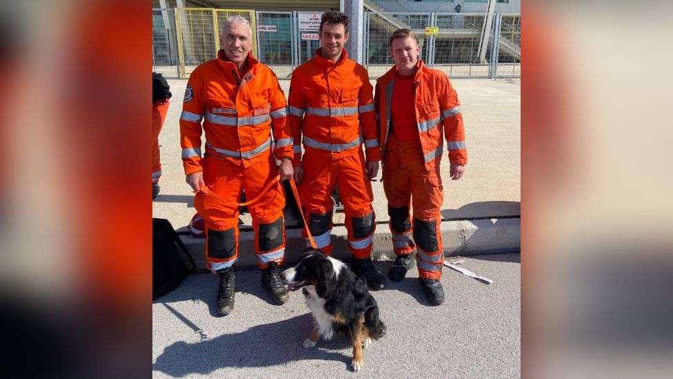 Three firefighters with rescue dog