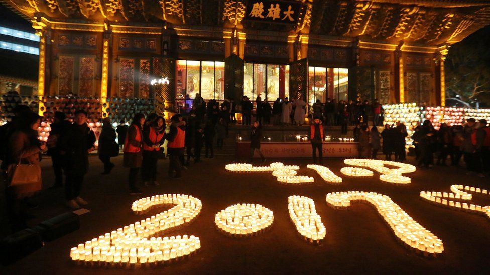Buddhists light candles during New Year celebrations at Jogye Buddhist temple in Seoul, South Korea
