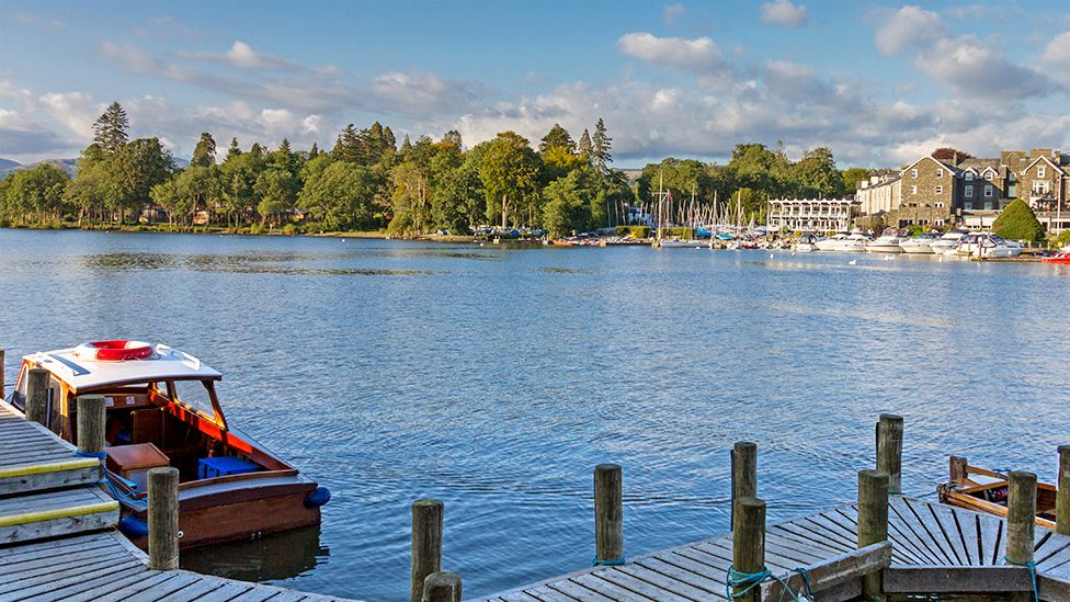 Bowness-on-Windermere harbour with wooden boat and pier in the foreground