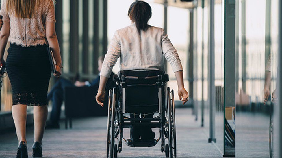 A woman in a wheelchair in an office