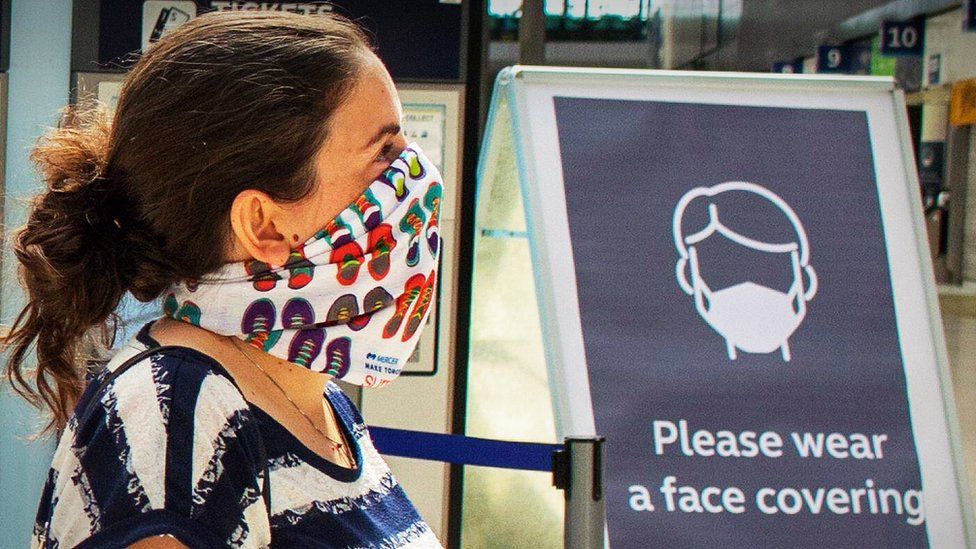 Woman at railway station wearing a face mask