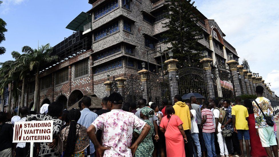 Residents and church members gather at the main gate of The Synagogue Church of All Nations (SCOA) headquarters to mourn the death of late Nigerian pastor TB Joshua, in the Ikotun distrcit of Lagos on June 6, 2021