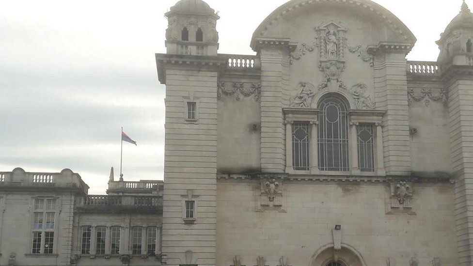 The bi-visibility flag in pink, lavender and blue flying over Cardiff University