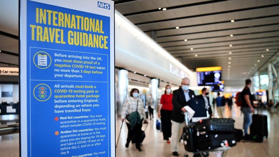 Travellers pass a sign at Heathrow