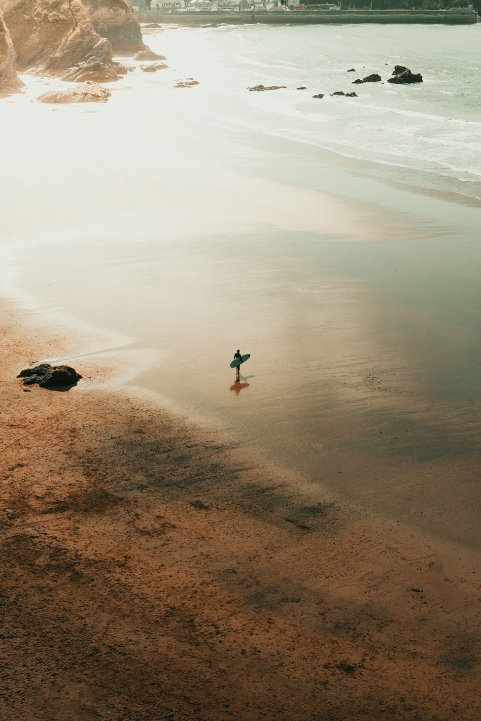 A solitary surfer on an empty Cornish beach